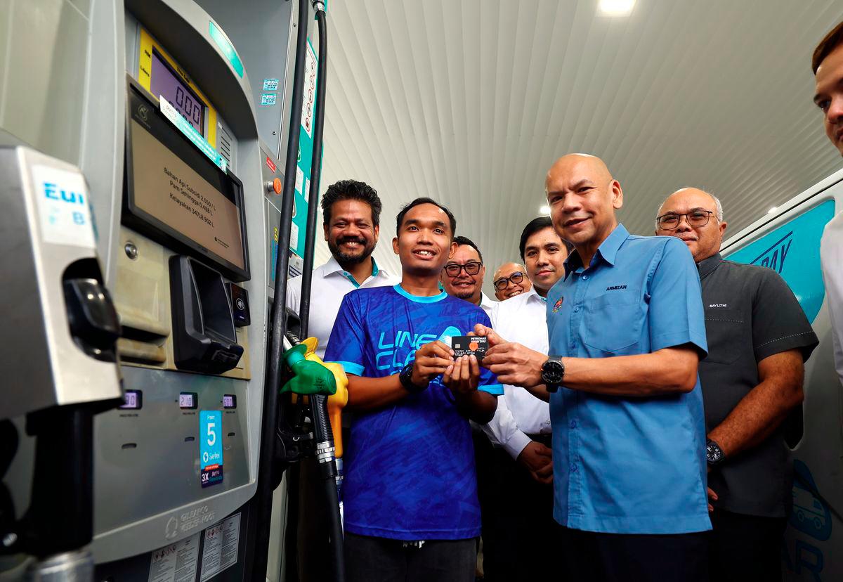 Menteri Perdagangan Dalam Negeri dan Kos Sara Hidup Datuk Armizan Mohd Ali bersama kakitangan Line Clear Express Sdn Bhd Muhammad Azim Asyraf Nasaruddin yang menerima kad fleet bagi kenderaan syarikat pada Majlis Penyerahan Kad Fleet di Stesen Minyak Petronas, Cyberjaya hari ini. - BERNAMA