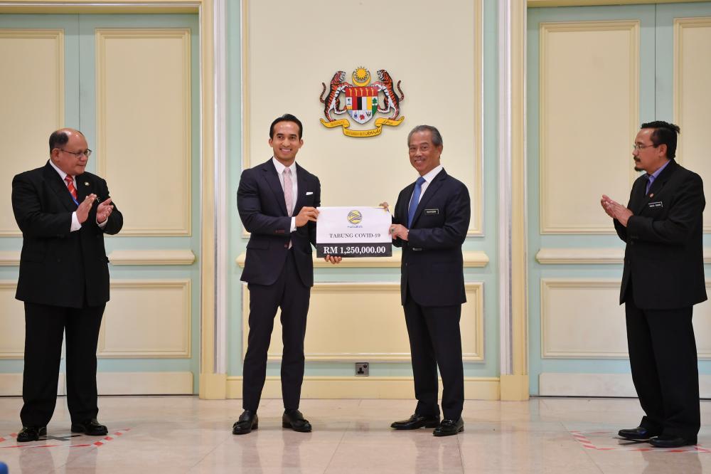 Prime Minister Tan Sri Muhyiddin Yassin receives a donation for the Covid-19 Fund from Naza Corporation Holdings Sdn Bhd group executive chairman SM Nasaruddin SM Nasimuddin at the Perdana Putra today. - Bernama