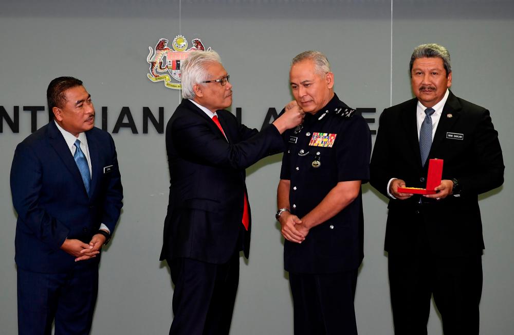Home Minister Datuk Seri Hamzah Zainudin (2nd from L) awards Datuk Seri Acryl Sani Abdullah Sani (2nd from R) at the Ministry of Home Affairs (KDN) today. - Bernama