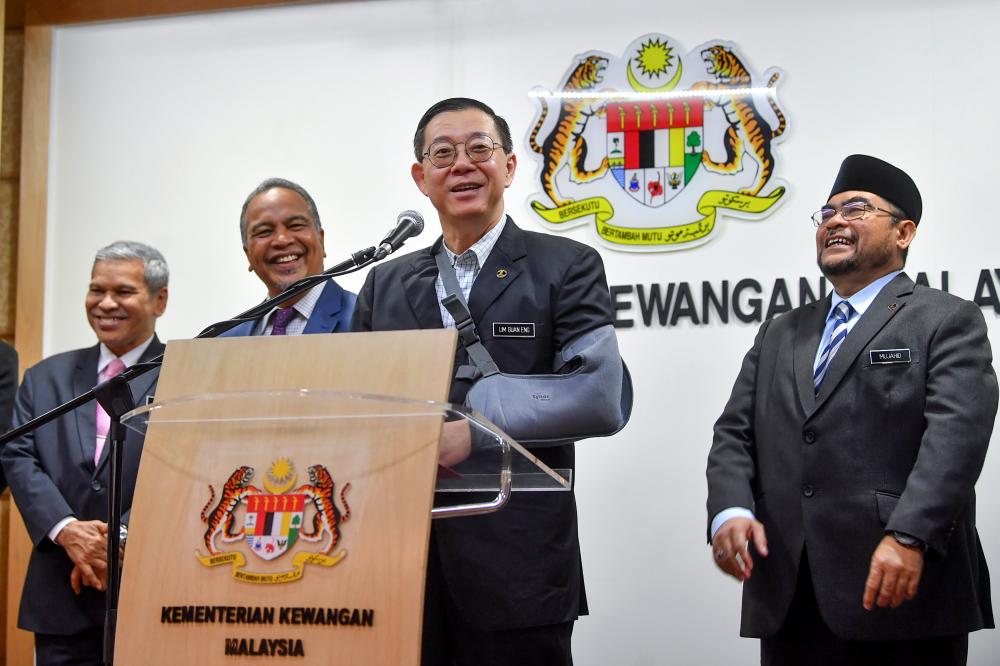 Finance Minister Lim Guan Eng and Minister in the Prime Minister’s Department Datuk Seri Dr Mujahid Yusof (R) attend a press conference after the handing over of the RM100 million allocation for tahfiz, sekolah agama rakyat and pondok schools at the Finance Ministry today. - Bernama