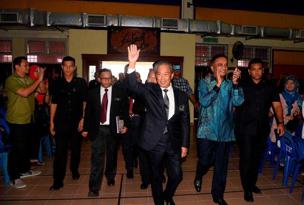 Prime Minister Tan Sri Muhyiddin Yassin waves to students, parents and teachers during a surprise visit to Sekolah Sultan Alam Shah to congratulate students who had excelled in SPM 2019. - Bernama