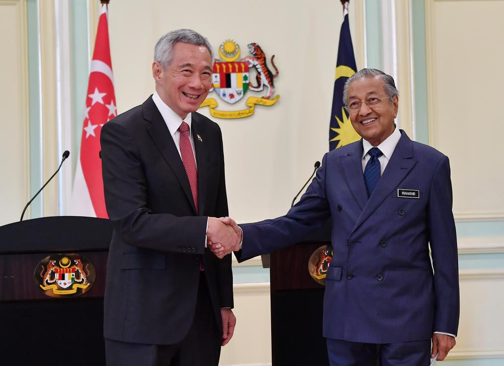 Prime Minister Tun Dr Mahathir Mohamad (R) shake hands with the Singapore Prime Minister Lee Hsien Loong after a media conference in conjunction with the Ninth Malaysia-Singapore Leadership Retreat at Perdana Putra Building, on April 9, 2019. — Bernama