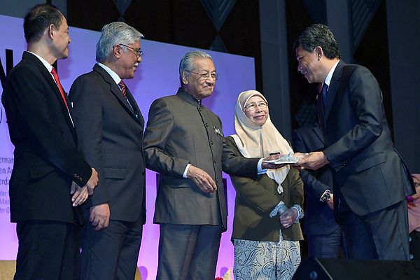 Umno deputy president Datuk Seri Mohamad Hassan (R) receives a copy of the NACP from Prime Minister Tun Dr Mahathir Mohamad during the launch of the NACP at the Putrajaya International Convention Centre on Jan 29, 2019. — Bernama