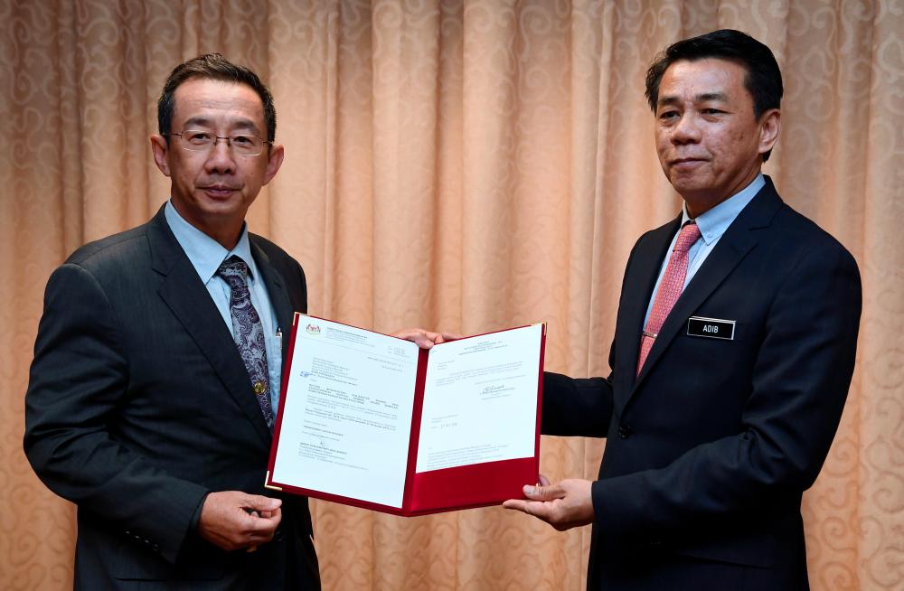 Datuk Mohd Khairul Adib (R) handed over a warrant listing 385 positions to be filled for the new Rembau Hospital, to Health Ministry secretary-general Dr Chen Chaw Min in a media conference on Dec 2, 2019. — Bernama