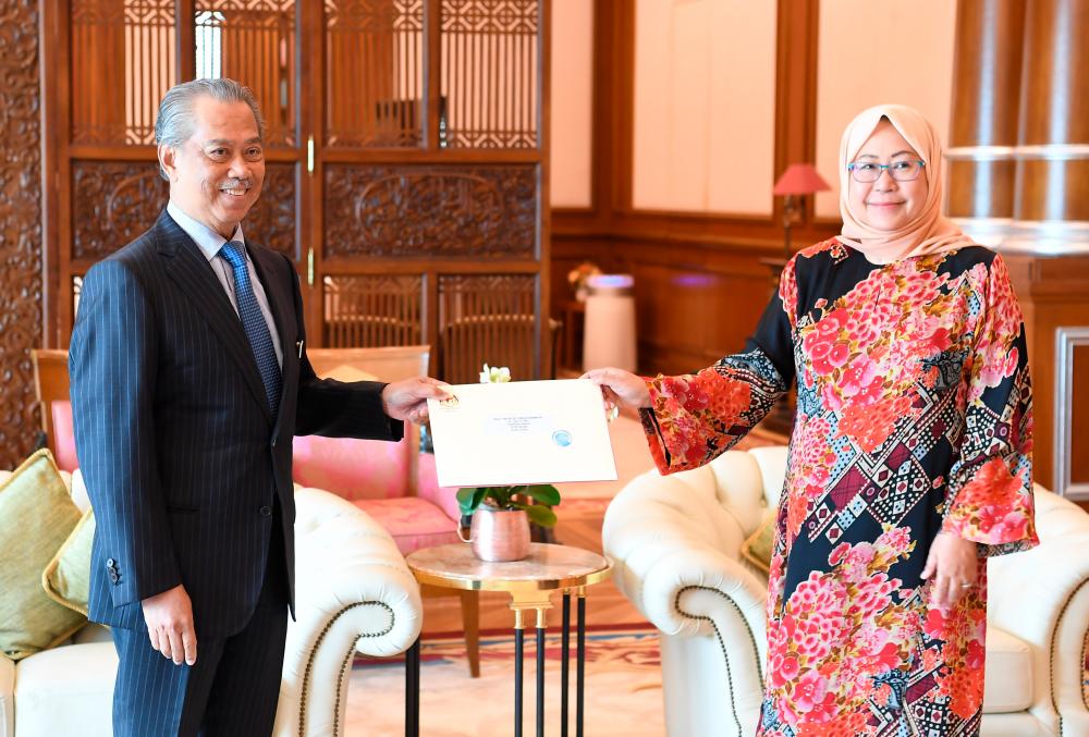 Prime Minister Tan Sri Muhyiddin Yassin hands over the appointment letter to Special Advisor to the Prime Minister on public health Tan Sri Dr Jemilah Mahmood, at his office in Perdana Putra today. - Bernama
