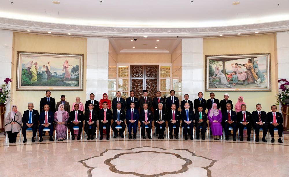 Prime Minister Tan Sri Muhyiddin Yassin (seated, centre) poses with a cabinet ministers before chairing the first new cabinet meeting at the Perdana Putra today.  — Bernama