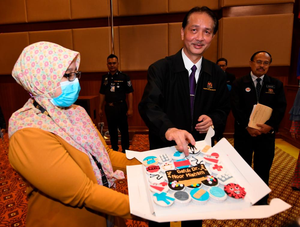 Health director-general Datuk Dr Noor Hisham Abdullah sees a cake handed out by members of the media in conjunction with his 57th birthday, following the daily press conference on Covid-19 infections at the Ministry of Health today. - Bernama