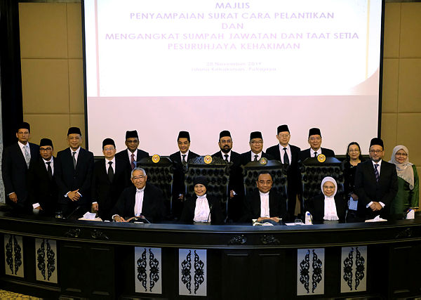 Chief Justice Tan Sri Tengku Maimun Tuan Mat, (sitting two, left) together with 13 Judicial Commissioners who were confirmed as High Court judges yesterday. — Bernama