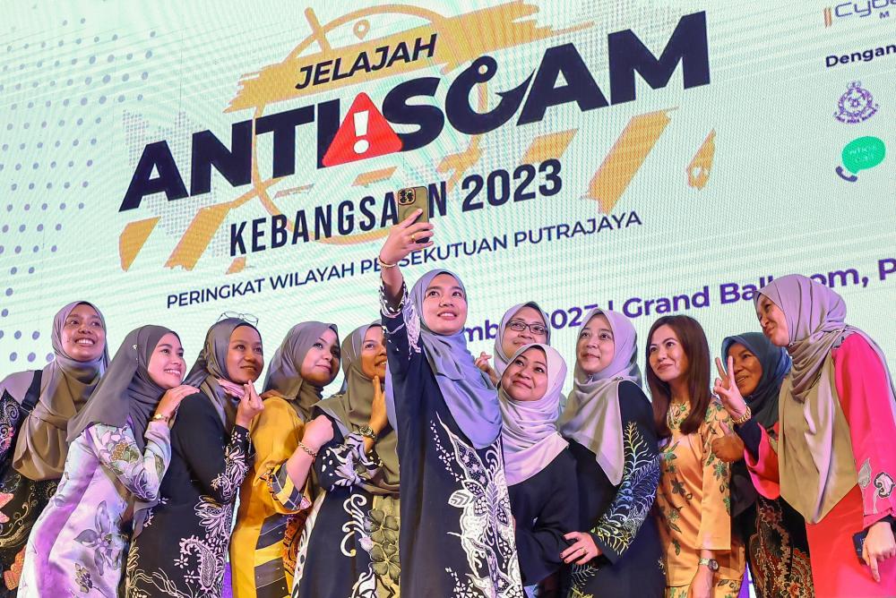 Staff of the Ministry of Communications and Digital take selfies with each other after the closing of the 2023 National Anti-Scam Tour. - BERNAMAPIX