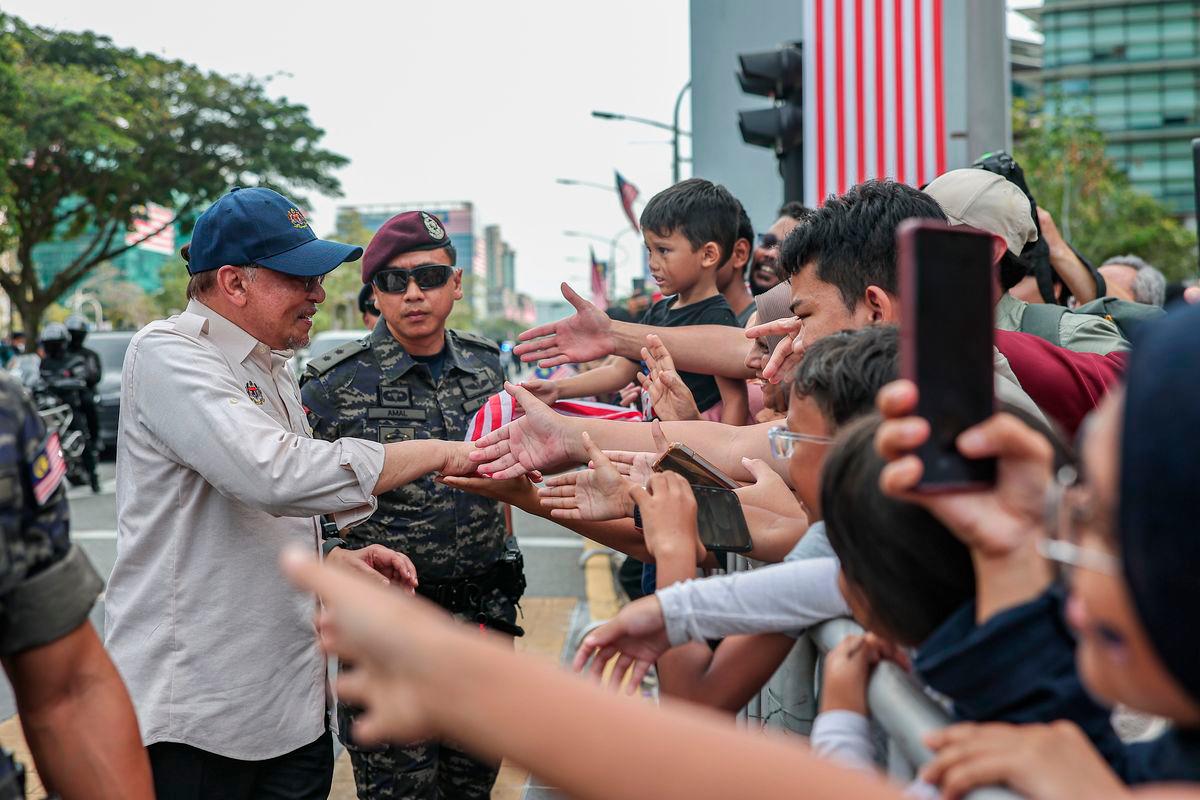 Perdana Menteri Datuk Seri Anwar Ibrahim menyantuni orang ramai pada perbarisan Sambutan Hari Kebangsaan 2025 di Dataran Putrajaya hari ini - fotoBERNAMA
