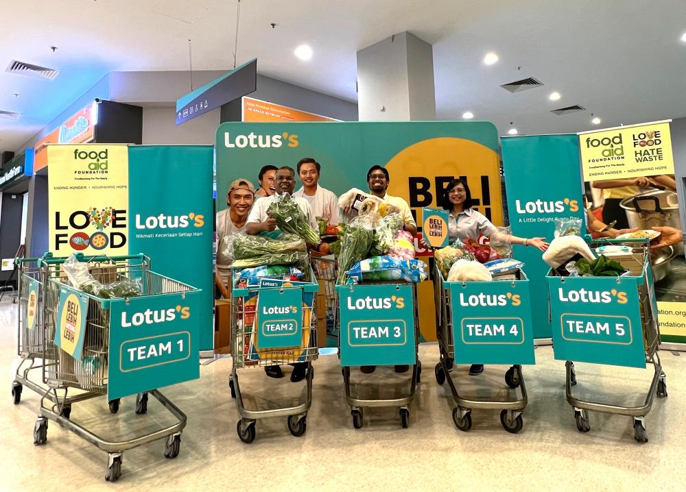 $!Neil (left) and Lotus’s Malaysia corporate services executive director Azliza Azmel (right) handing over the Media Scavenger Hunt for Charity provisions weighing more than 1,300kg of essential food items to Food Aid Foundation, represented by its programme and CSR manager Muhammad Izzul Izham Mohammad Nordin (centre).