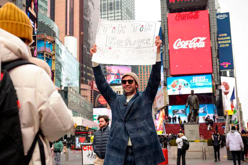 A social media influencer films a video for his new Xiaohongshu, also known as RedNote, after leaving TikTok, in Times Square in New York City - REUTERSpix