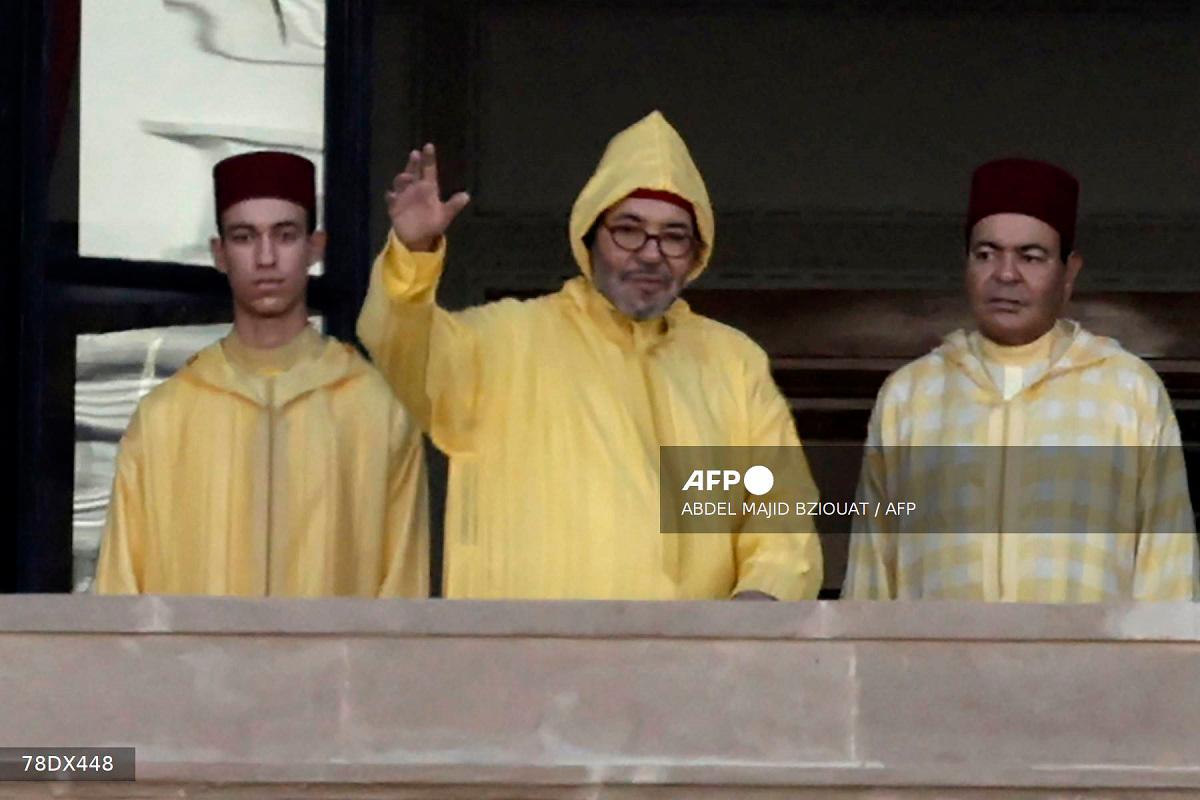Morocco's King Mohammed VI (C), accompanied by his son, Crown Prince Moulay Hassan (L) appears on the balcony of the Parliament headquarters in Rabat on October 10, 2025. - Abdel Majid BZIOUAT / AFP