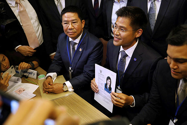 An official of Raksa Chart party holds the registration document bearing the photograph of Thai Princess Ubolratana prior to submitting to election commission officials in Bangkok — AFP