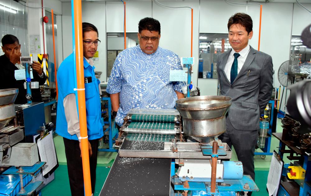 Ab Rauf (centre) being briefed by Koa Denko mangaing director Seiji Ozawa (right) during his visit to Koa Denko (Malaysia) Sdn Bhd on Dec 21. BERNAMAPIC