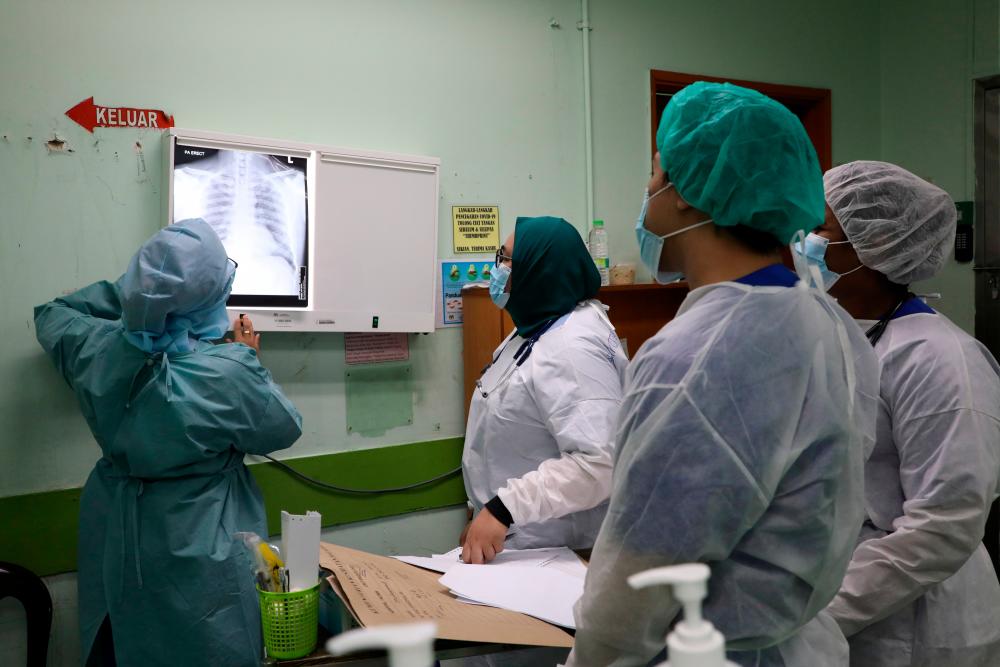 Health workers look at x-rays of a patient at Emergency Department in the Kuala Lumpur Hospital, amid the coronavirus disease (COVID-19) outbreak, in Kuala Lumpur, Malaysia May 23, 2020. — Reuters