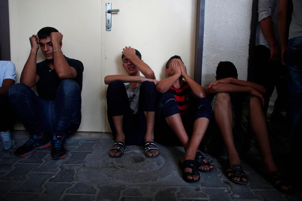 Relatives of Palestinian gunmen who were killed by Israeli forces as they tried to cross the Gaza border, react at a hospital in the northern Gaza Strip August 18, 2019. - Reuters