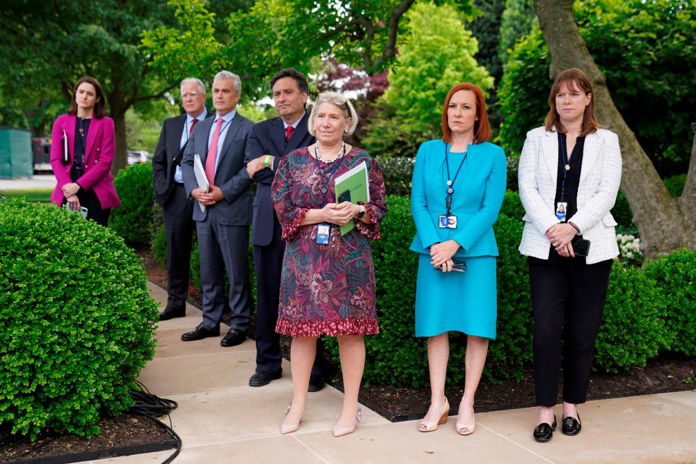 White House Press Secretary Jen Psaki, Communications Director Katherine Bedingfield and other staff members stand without protective face masks at the Rose Garden of the White House in Washington, US., May 13, 2021 -Reuters