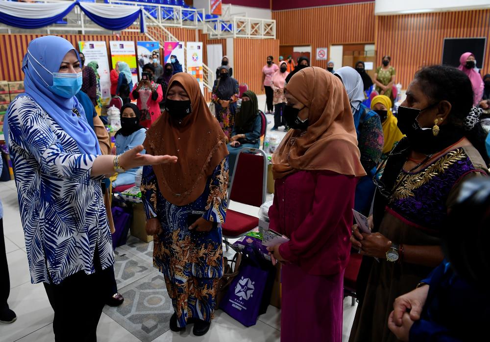 Menteri Pembangunan Wanita, Keluarga dan Masyarakat Datuk Seri Rina Mohd Harun (kiri) menyantuni sebahagian daripada ibu tunggal yang hadir pada Program Kembara Prihatin Negara (KPN) – Bantuan Khas Ibu Tunggal (BKIT) di Pusat Latihan Perindustrian dan Pemulihan (PLPP) Bangi, hari ini.  Seramai 44 ibu tunggal diraikan pada program tersebut. — Bernama