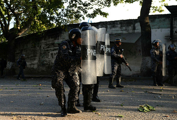 Riot police clash with anti-government demonstrators in the neighborhood of Los Mecedores, in Caracas. — AFP