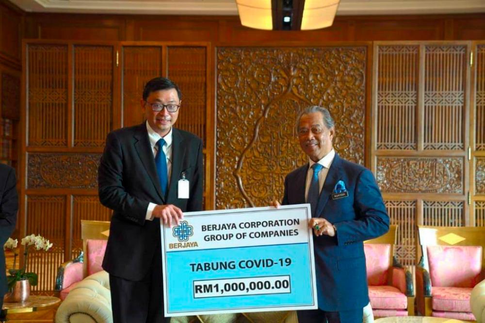 Berjaya Corporation Berhad CEO Datuk Seri Robin Tan Yeong Chin (L) presents a mock cheque to Prime Minister Tan Sri Muhyddin Yassin, after Berjaya Group today donated RM1 million to the Covid-19 fund.