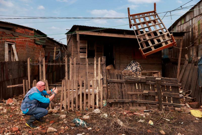 Andrew Harper, climate advisor for the UN refugee agency (UNHCR), photographs a house partially destroyed by the floods that hit Porto Alegre, in the state of Rio Grande do Sul, Brazil, June 23, 2024. - REUTERSPIX