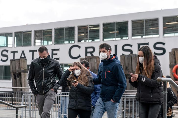 Visitors wearing surgical masks are seen following the outbreak of coronavirus disease (COVID-19), in New York City. -Reuters