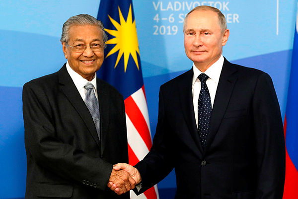 Russian President Vladimir Putin shakes hands with Prime Minister Mahathir Mohamad (L) during their meeting at the Eastern Economic Forum in Vladivostok today. — AFP