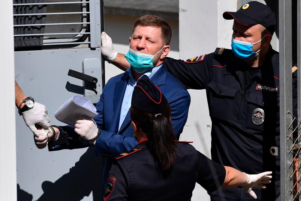 Russia’s Khabarovsk region governor Sergei Furgal is escorted into a police van after a court hearing in Moscow on July 10, 2020. — AFP