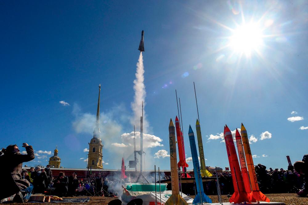 Bystanders watch the launch of model rockets near The Peter and Paul Fortress in Saint Petersburg on April 11, 2021, during a celebration of the 60th anniversary of Russia’s Yuri Gagarin’s first manned flight into space. - AFP