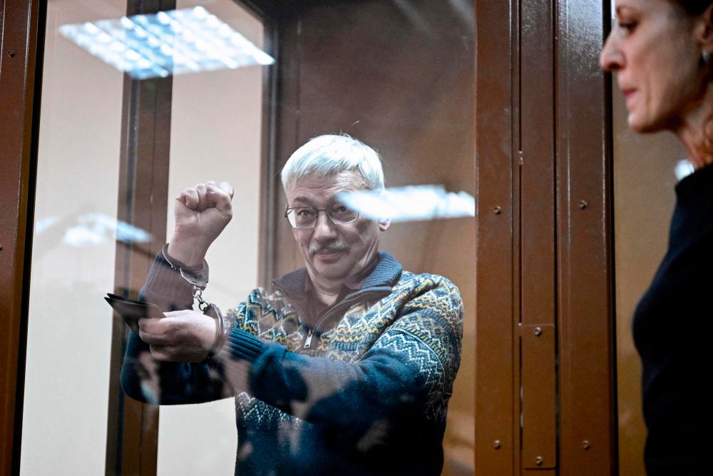 Oleg Orlov, the 70-year-old human rights campaigner and co-chair of the Nobel Prize winning Memorial group, is seen handcuffed after being sentenced to two and a half years in jail on charges of repeatedly “discrediting” the Russian army, in Moscow on February 27, 2024/AFPPix