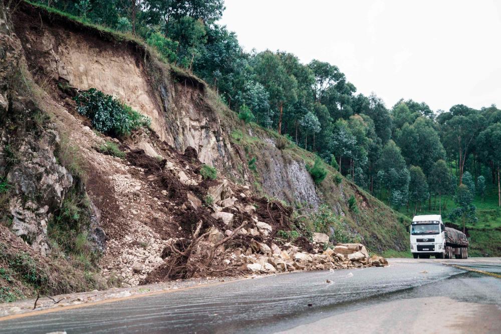 Debris partially covers a road following a landslide after heavy rain in Rubengera, Rwanda, on May 3, 2023. At least 127 people have died as floods and landslides engulfed several parts of Rwanda after torrential rains, destroying homes and cutting off roads, the presidency said Wednesday. AFPPIX