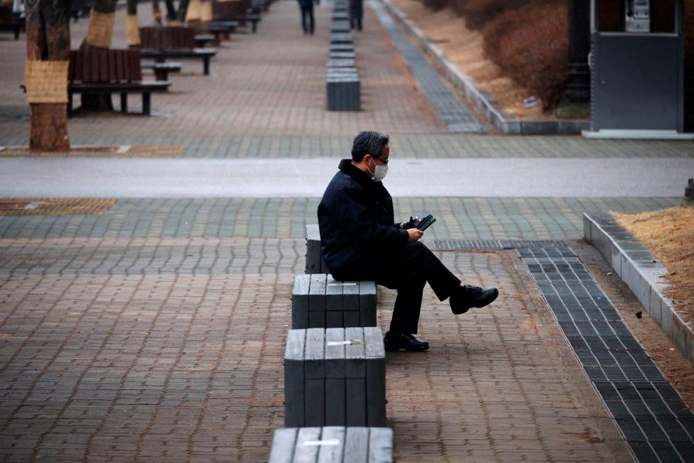 A man wearing a mask to prevent contracting the coronavirus disease (Covid-19) rests at an empty park in Seoul, South Korea, January 25, 2022. REUTERSpix