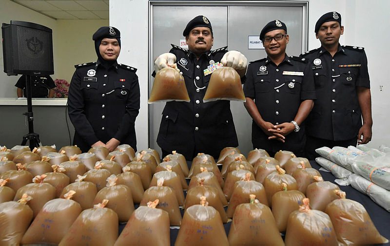 Sentul District police chief ACP S. Shanmugamoorthy (2nd L) the holds plastic packets of ketum water seized, during a press conference on April 26, 2019. — Bernama