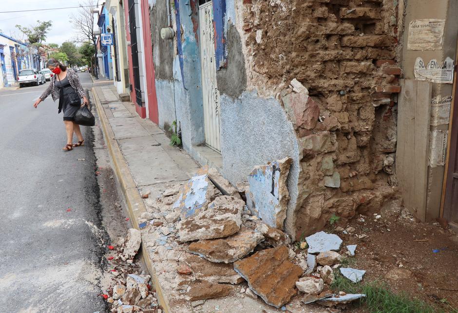 A woman walks by a building damaged during a quake, in Oaxaca, Mexico June 24, 2020. -Reuters