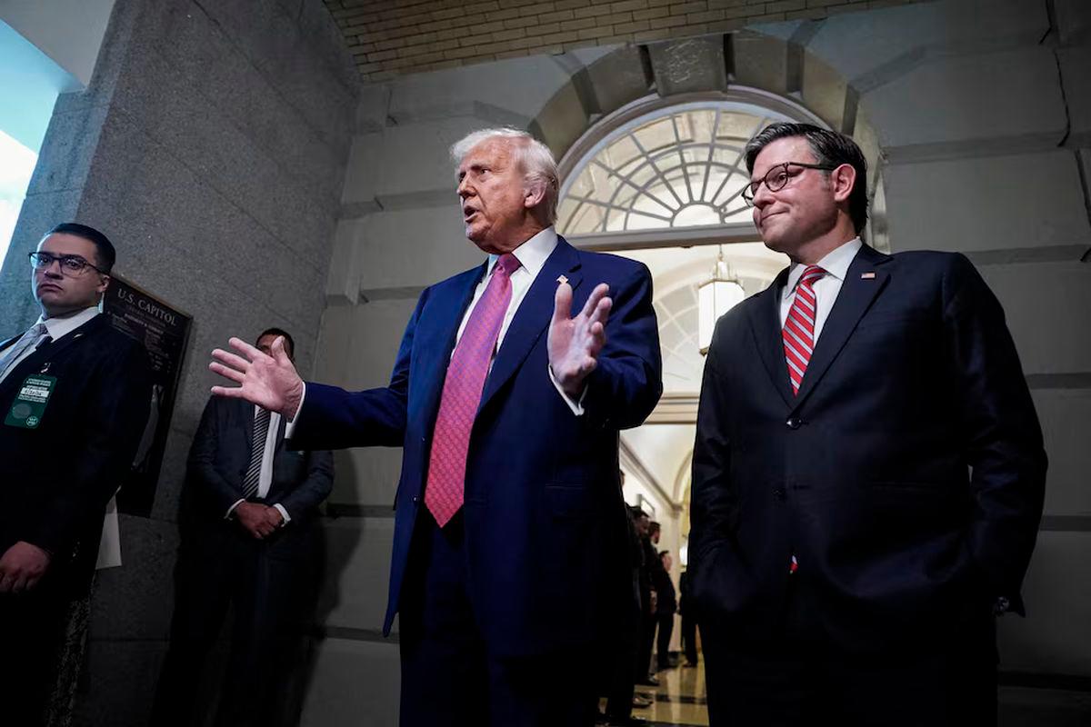 U.S. President Donald Trump gestures next to U.S. House Speaker Mike Johnson (R-LA), on the day of a closed House Republican Conference meeting on Capitol Hill in Washington, D.C., U.S., May 20, 2025. REUTERS/Ken Cedeno