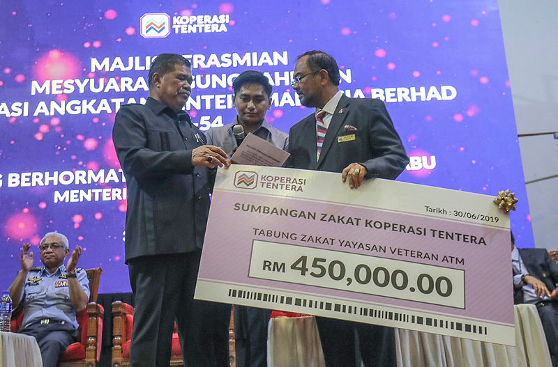 Defence Minister Mohamad Sabu presents a mock cheque from the Zakat Fund of the Malaysian Armed Forces Foundation to the Chairman of the Military Cooperative, Datuk Zulkiflee Mazlan, on June 30, 2019. — Sunpix by Amirul Syafiq