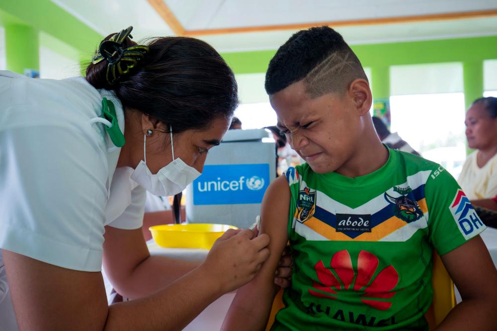 This handout picture taken on Dec 2, and released from Unicef Samoa on Dec 4 shows a boy receiving a vaccine during a nationwide campaign against measles in the Samoan town of Le'auva'a. — AFP