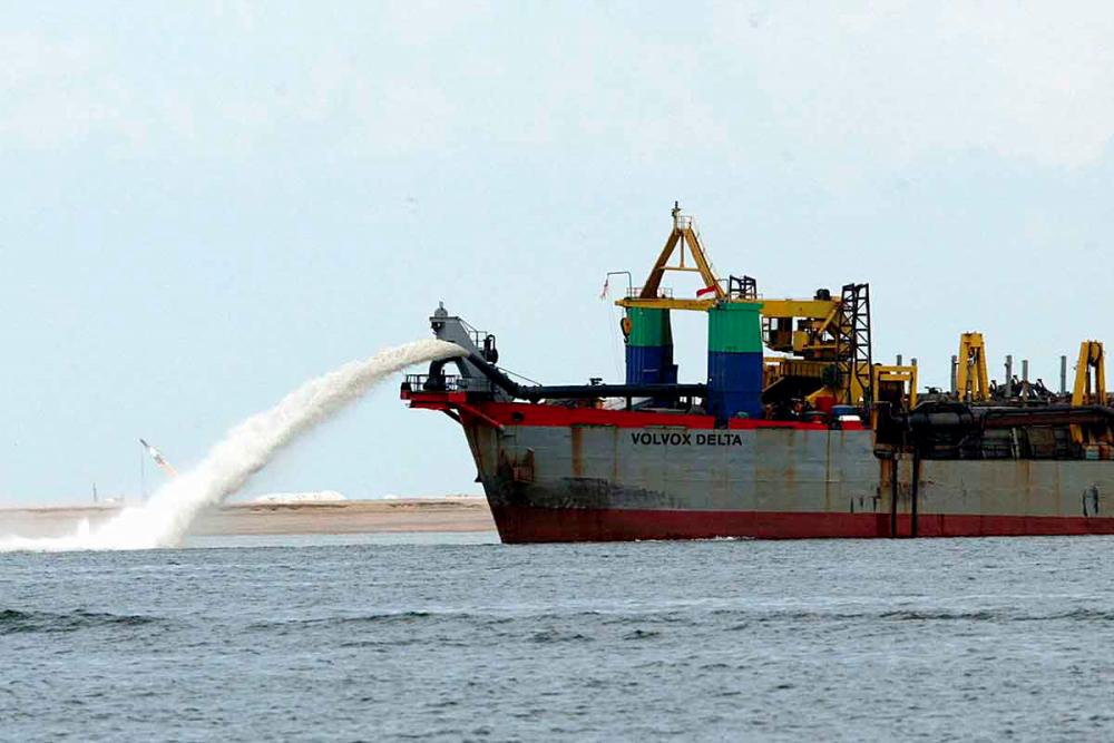 A dredger vessel spewing sand to fill the seabed for reclamation off western Singapore. — AFP