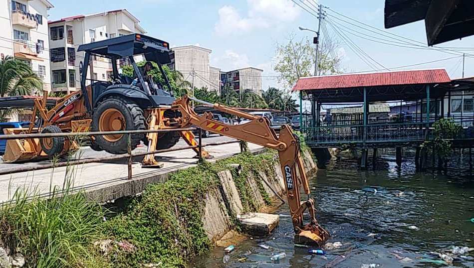 A JKR excavator scooping up rubbish from a monsoon drain at Jalan Sim Sim. — Pix courtesy of The Borneo Post