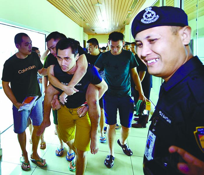 Mark Roger, 24, who was among 47 Malaysians jailed in Cambodia for alleged involvement in illegal online gambling activities, is carried by a friend from among the group who arrived at the Kuching International Airport, on Feb 17, 2019. — Bernama