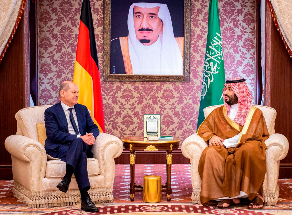 This handout picture provided by the Saudi Royal Palace shows (R to L) Saudi Crown Prince Mohammed bin Salman receiving Germany’s Chancellor Olaf Scholz at al-Salam Palace in the Red Sea coastal city of Jeddah on September 24, 2022. AFPPIX