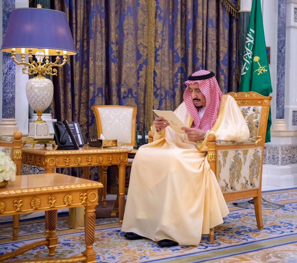 A handout picture provided by the Saudi Royal Palace on March 8, 2020, shows Saudi Arabia's King Salman bin Abdulaziz reading documents at the Royal Palace in the capital Riyadh. - AFP