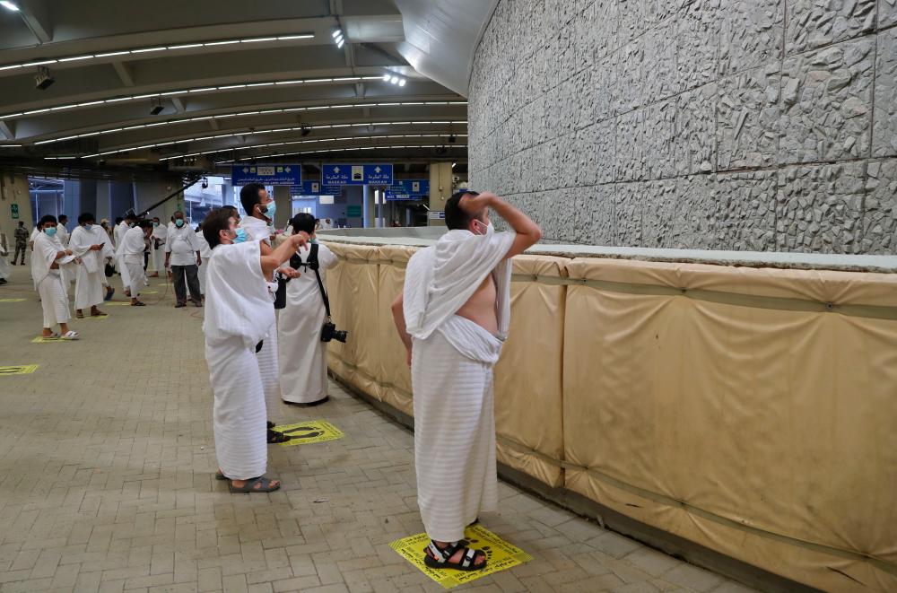 A picture taken on July 31, 2020 shows Muslim worshippers throwing pebbles as part of the symbolic al-A'qabah (stoning of the devil ritual) at the Jamarat Bridge during the Hajj pilgrimage in Mina, near Saudi Arabia's holy city of Mecca. — AFP