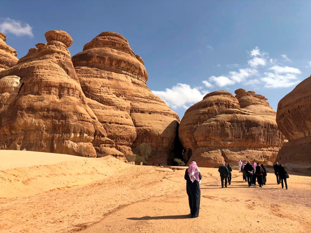 Visitors walk outside the tombs at the Madain Saleh antiquities site, al-Ula, Saudi Arabia. The kingdom wants the tourism sector to contribute 10% of gross domestic product by 2030. – REUTERSPIX