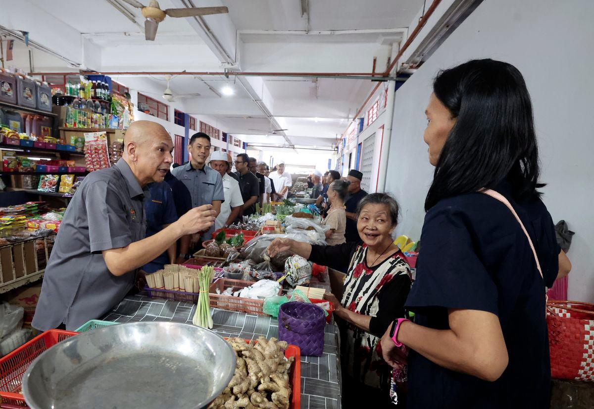 Menteri Perdagangan Dalam Negeri dan Kos Sara Hidup, Datuk Armizan Ali, berinteraksi mesra dengan peniaga di Pasar Am Papar ketika melakukan walkabout di Pekan Papar, hari ini. - fotoBERNAMA