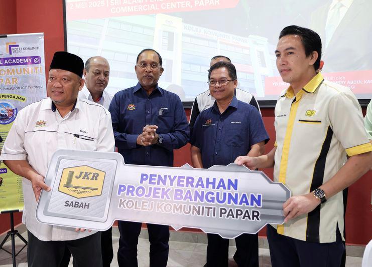 Menteri Pendidikan Tinggi Datuk Seri Zambry Abdul Kadir (tiga, kanan) bersama timbalannya Datuk Mustapha Sakmud (dua, kanan) menyaksikan acara penyerahan kunci bangunan Kolej Komuniti Papar daripada Jurutera Daerah Jabatan Kerja Raya Papar Ir. Mohamed Ibni Sabul (kanan) kepada Setiausaha Bahagian Pembangunan, Ghazali Hizam (kiri) pada majlis penyerahan Kolej Komuniti Papar di Pusat Komersil Sri Alam Perdana hari ini. - fotoBERNAMA