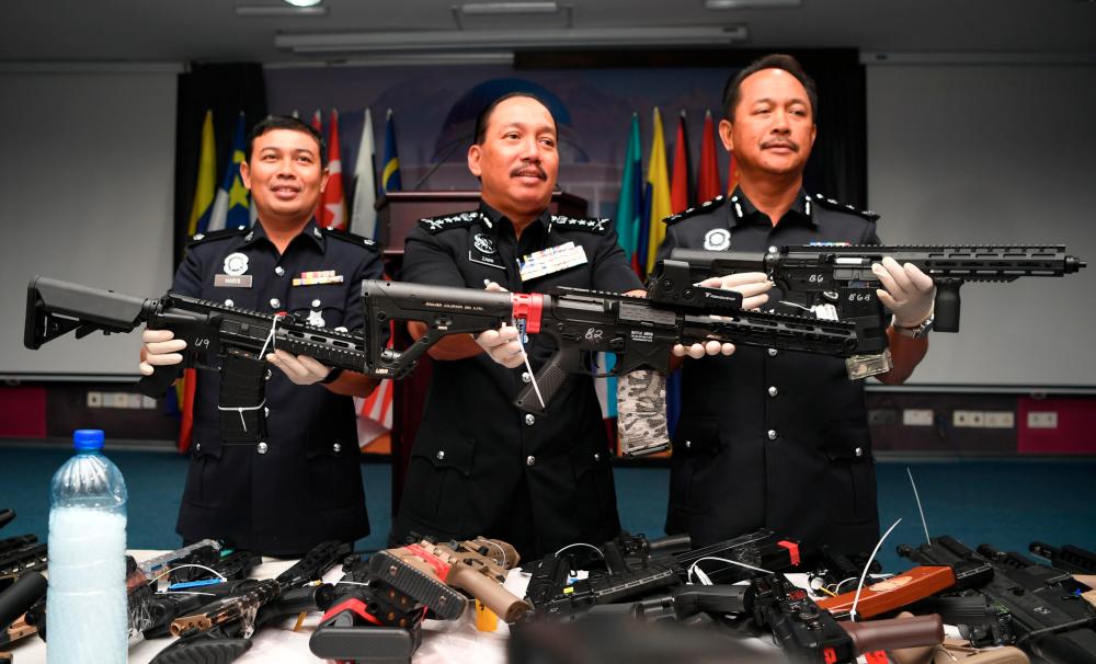 Sabah Police Commissioner Datuk Zaini Jass (C) displays the seized Gelsoft weapons at a press conference at the Kota Kinabalu police headquarters today. - Bernama