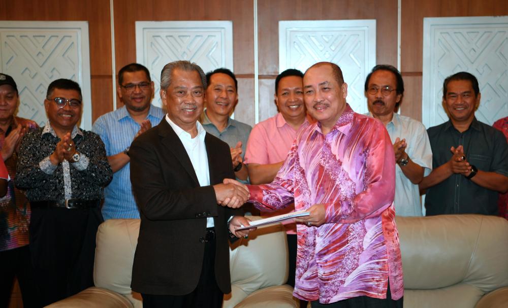 Home Minister Tan Sri Muhyiddin Yassin, who is also Bersatu president, hands over the approval letter from RoS to the party’s Sabah coordinator Datuk Hajiji Noor in a brief ceremony in Kota Kinabalu on May 5, 2019. - Bernama
