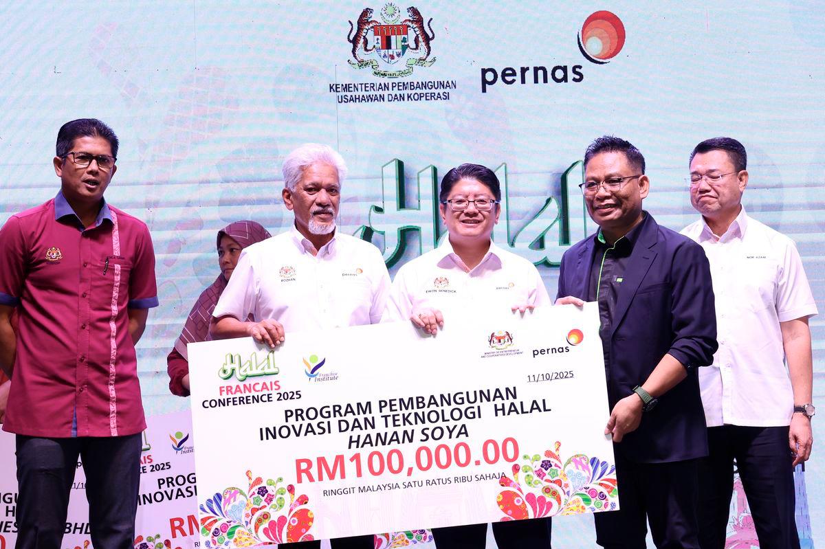 Menteri Pembangunan Usahawan Dan Koperasi Datuk Ewon Benedick menyampaikan sijil penyertaan kepada peserta program Halal Francise Conference di Meridien Hotel hari ini. - BERNAMA
